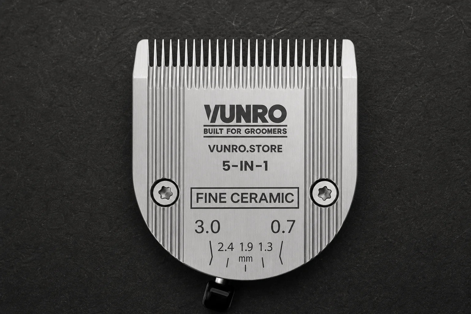 Adjustable Ceramic 5 in 1 Fine Dog Clipper Blade (0.7 mm - 3 mm) on a dark grooming workbench